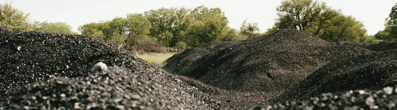 Large stockpiles of biochar in an open field